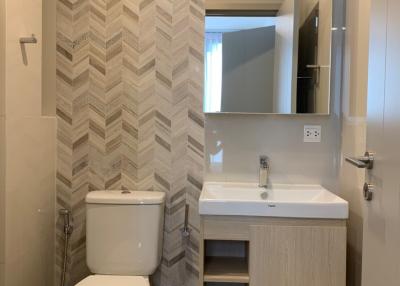 Modern bathroom interior with herringbone tile pattern and sleek fixtures