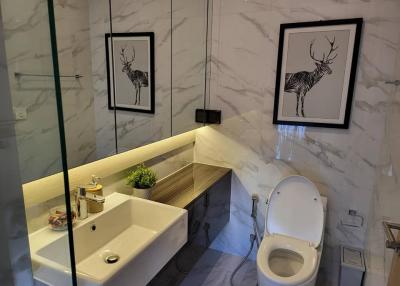 Modern bathroom with marble tiles and artwork