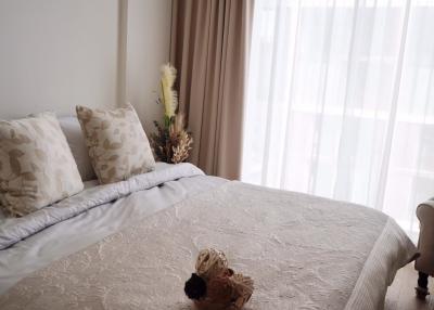 Cozy bedroom with a made bed, neutral color scheme, and ample natural light