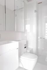 Modern white bathroom interior with glass shower and minimalist design