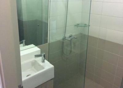 Modern bathroom with glass shower enclosure and wall-mounted sink