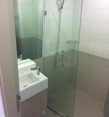 Modern bathroom with glass shower enclosure and wall-mounted sink
