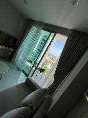 Modern living room with a sofa, large windows and balcony access