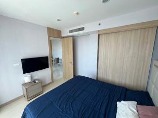 Spacious bedroom with large bed, built-in wardrobe, and modern amenities