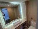 Modern bathroom with reflective vanity mirror and well-lit ambiance
