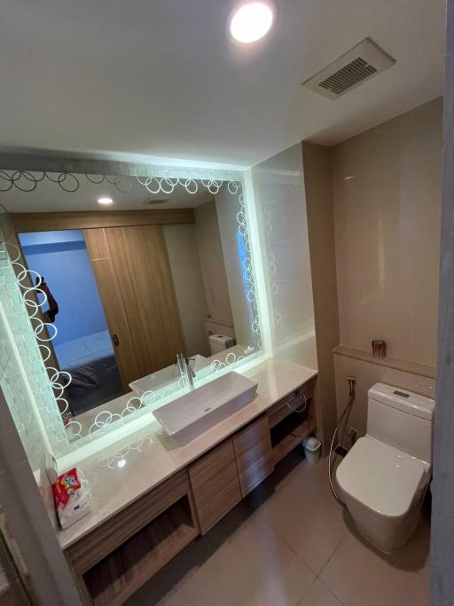 Modern bathroom with reflective vanity mirror and well-lit ambiance