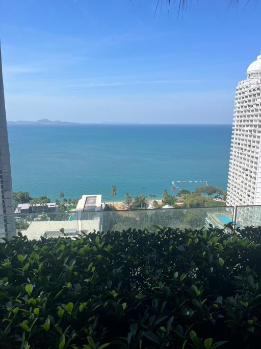 Scenic ocean view from a high-rise apartment balcony with clear blue skies