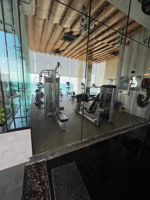 Modern home gym with glass walls and ocean view