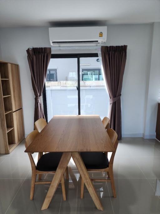 Modern dining room with a large table, chairs, and an air conditioner