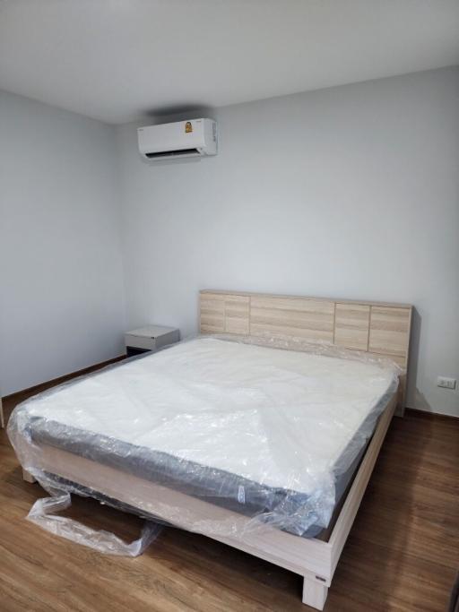 Spacious bedroom with a new king-sized bed and air conditioning unit