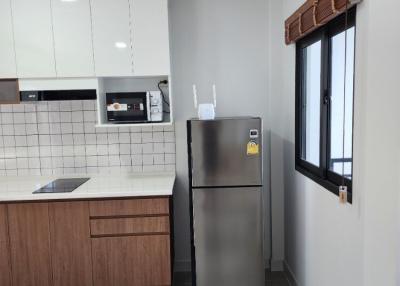 Modern kitchen with stainless steel refrigerator and wooden cabinets