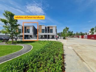 Modern townhouses with landscaped garden and clear blue skies