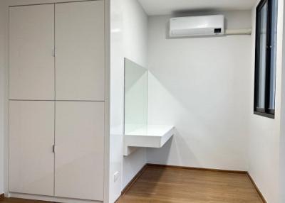 Minimalist bedroom with built-in wardrobe and air conditioning unit