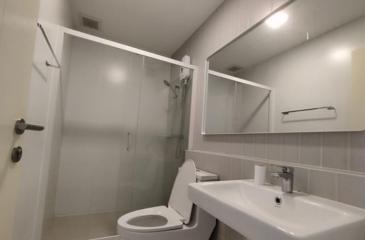 Modern white bathroom with shower, toilet, and sink