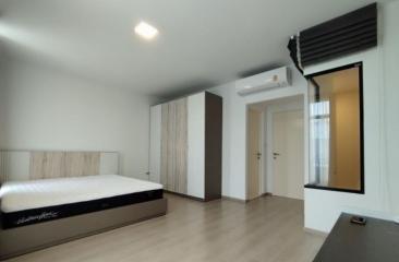 Modern bedroom with a large bed, air conditioning, and wooden flooring