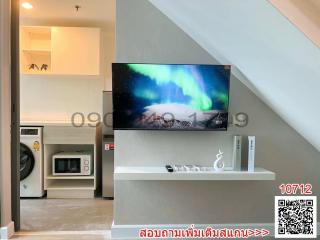 Modern living room with mounted television and adjacent kitchen area