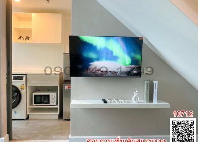 Modern living room with mounted television and adjacent kitchen area