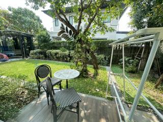 Cozy outdoor sitting area with lush greenery in a backyard garden