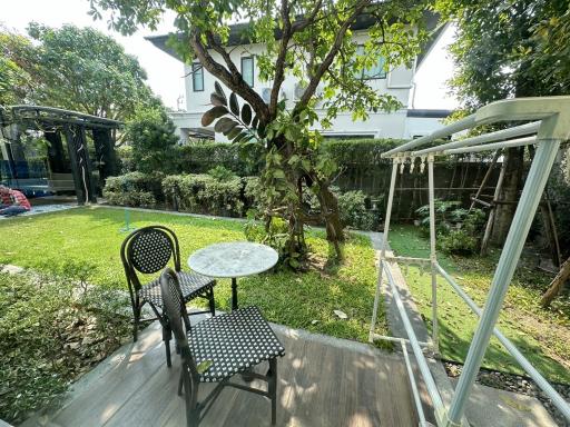 Cozy outdoor sitting area with lush greenery in a backyard garden