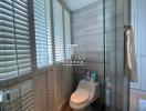 Modern bathroom interior with shutters and glass shower