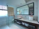 Modern bathroom with large mirror and city view