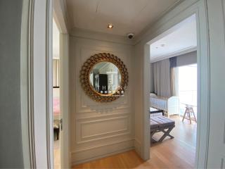 Elegant hallway with decorative mirror leading to a well-lit bedroom