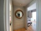Elegant hallway with decorative mirror leading to a well-lit bedroom