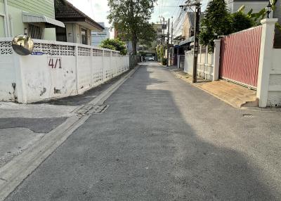 Paved street in a residential area with fencing on both sides