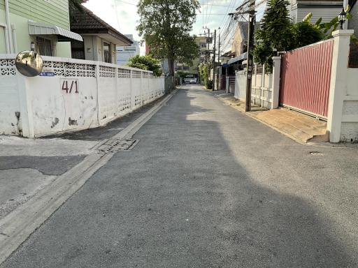 Paved street in a residential area with fencing on both sides