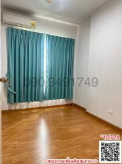 Empty bedroom with wooden flooring and turquoise curtains