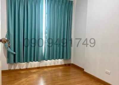 Empty bedroom with wooden flooring and turquoise curtains