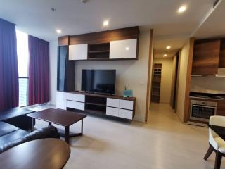Modern furnished living room with entertainment unit and open floor plan