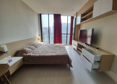 Modern bedroom with large window and mounted television