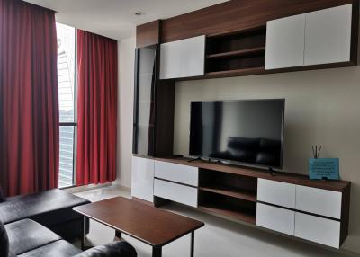 Modern and spacious living room with large windows and stylish entertainment unit