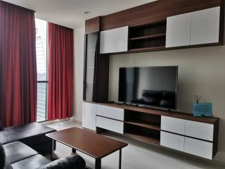 Modern and spacious living room with large windows and stylish entertainment unit