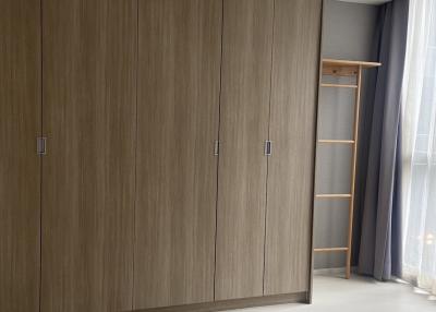 Spacious bedroom with a large wooden wardrobe and ceramic flooring