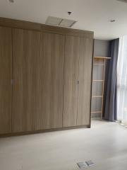 Spacious bedroom with a large wooden wardrobe and ceramic flooring