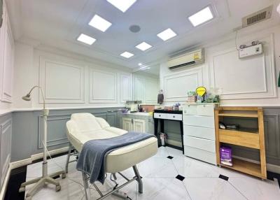 Modern clinic room with medical examination bed and sanitation station
