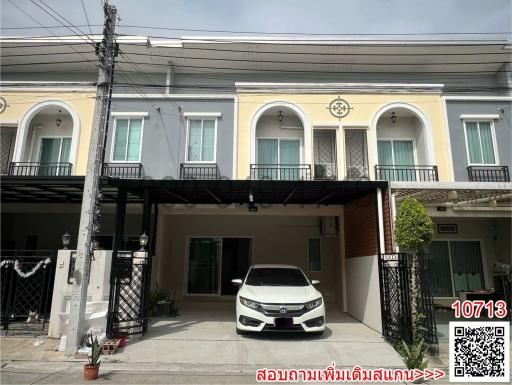 Modern two-story townhouse with car parked in front and balcony