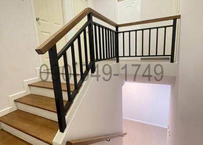 Modern staircase with wooden steps and black railings in a residential house