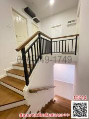 Modern staircase with wooden steps and black railings in a residential house