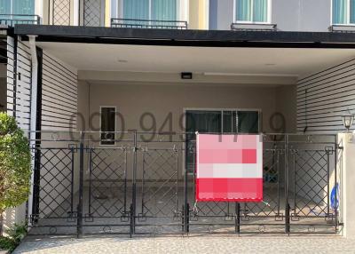 Two-story townhouse facade with balcony and gated entrance