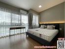Modern bedroom with a large bed, natural light and air conditioning