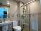 Modern bathroom interior with glass shower, sink, and toilet