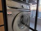 Modern washing machine in a small laundry area with city view