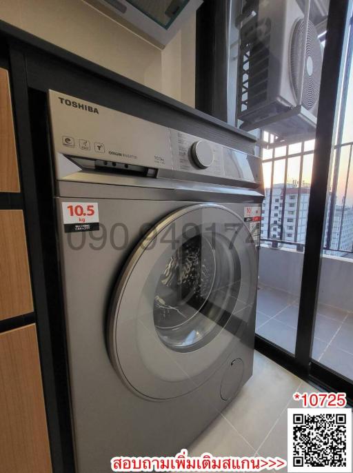 Modern washing machine in a small laundry area with city view