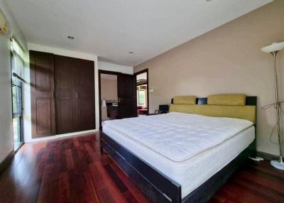 Spacious bedroom with wooden flooring and large bed