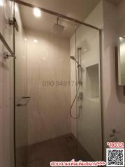 Modern bathroom with glass shower enclosure and beige tiles