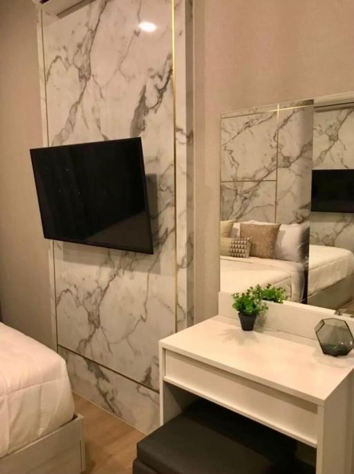 Modern bedroom interior with marble walls and mounted television