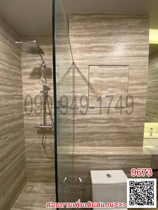 Modern bathroom with glass shower enclosure and textured wall tiles